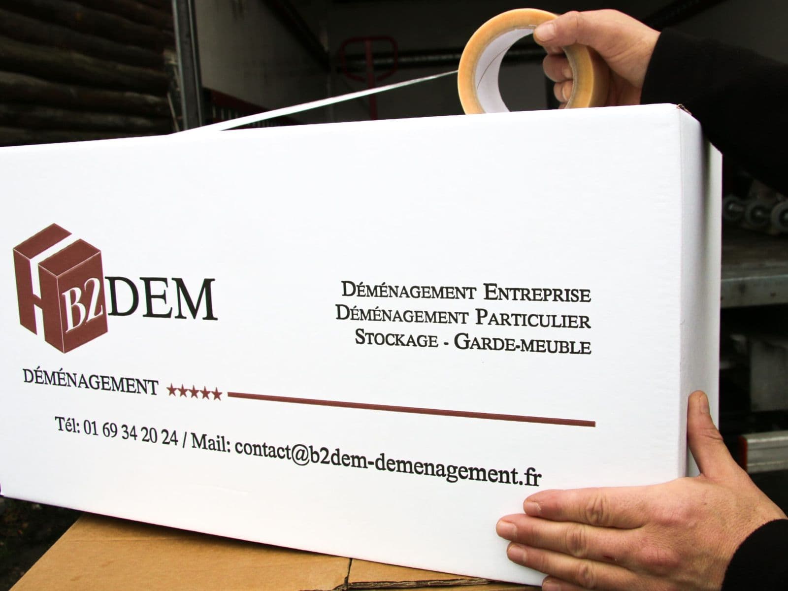 Un carton B2DEM qu'on referme au ruban adhésif